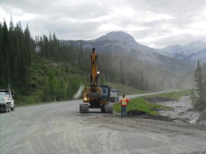Road crews were shoring up the road where it had been eroded by the fast moving water in the ditch