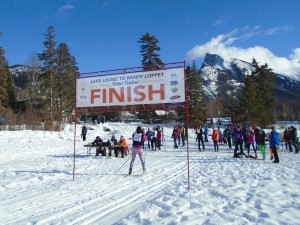 A skier crosses the finish line in the Lake Louise to Banff Loppet