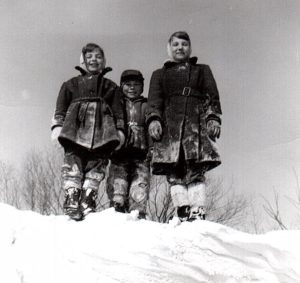 Three of my siblings on top of a snowbank in 1954